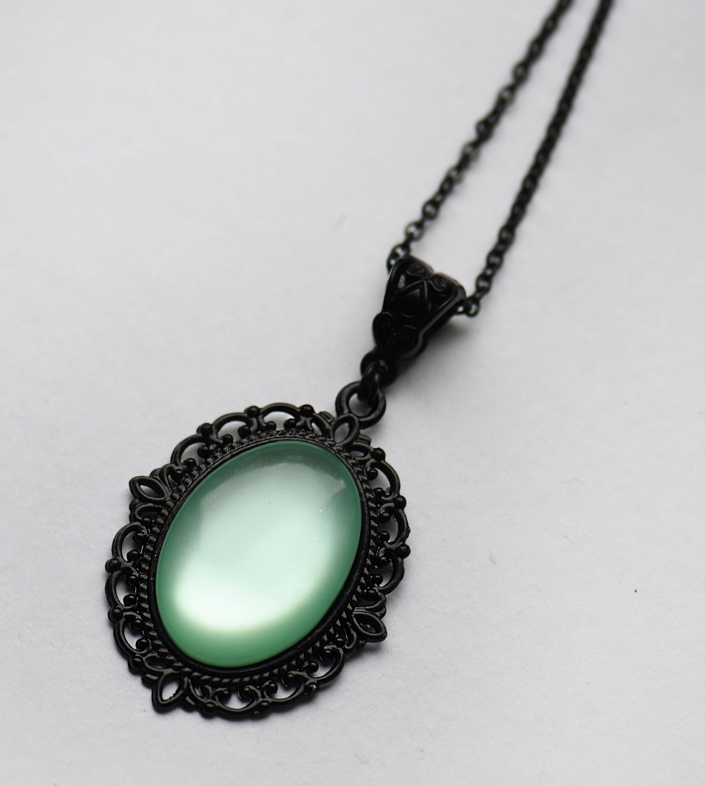 Gothic black necklace with a light green cabochon